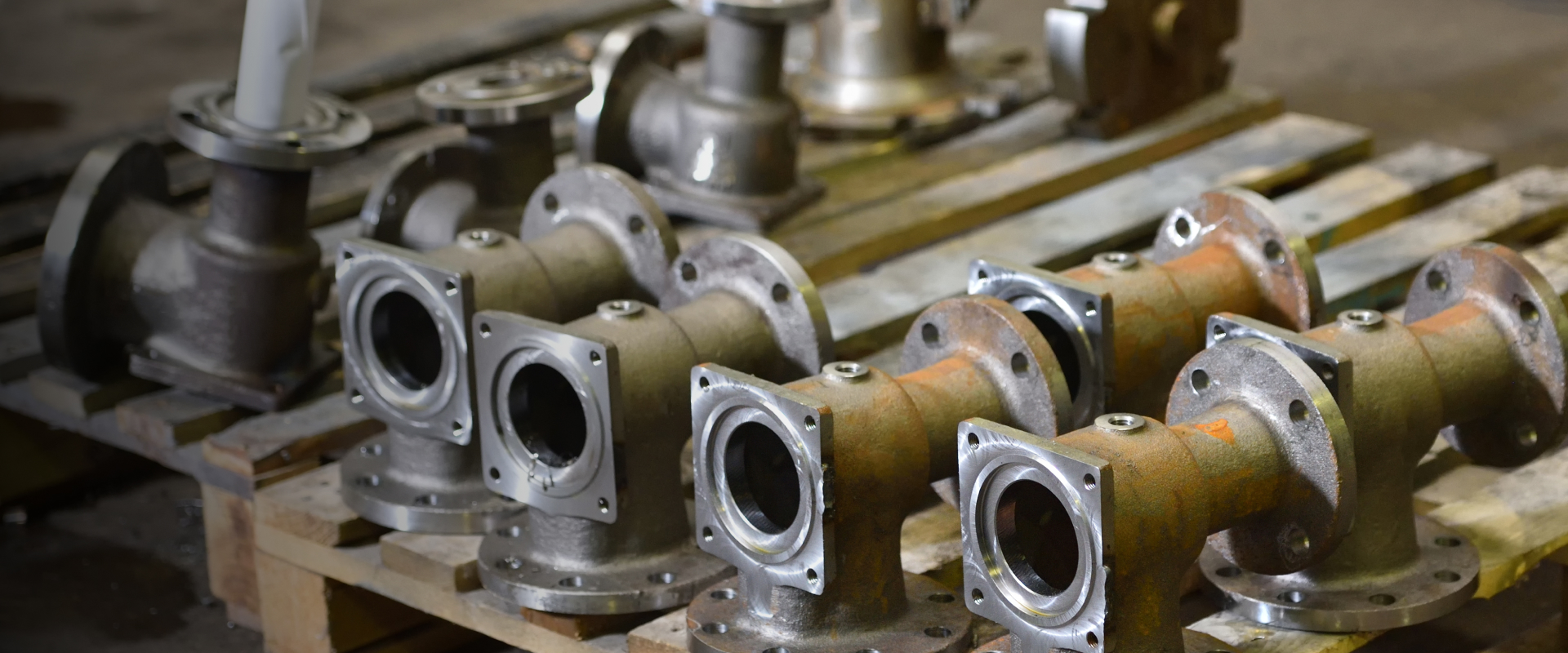 A view of valve body parts arranges on a table for industrial use.